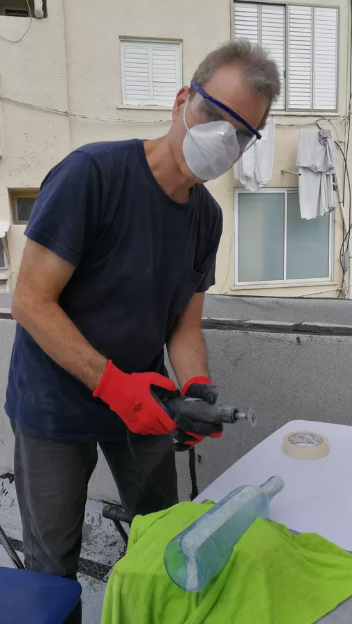אודי קרמסקי חותך בקבוקי זכוכית בתהליך חיתוך מאתגר